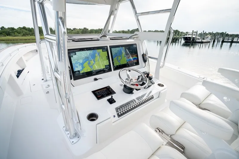 Slide: The Image of 2023 Invincible 39 Open Fisherman boat cockpit with dual navigation screens and plush seating. - 25