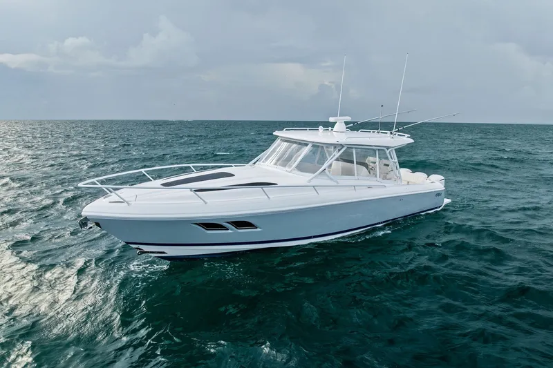 Slide: The Image of 2019 Intrepid 400 Cuddy cruising on open sea under cloudy skies. - 6