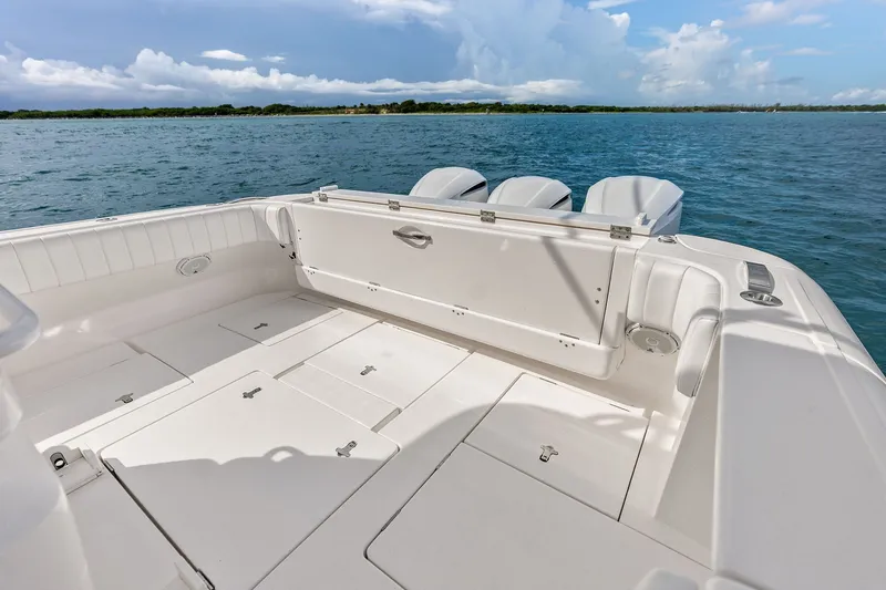 Slide: The Image of 2019 Intrepid 400 Cuddy boat deck with triple engines, on calm blue water. - 25