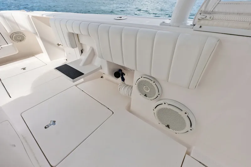 Slide: The Image of 2019 Intrepid 400 Cuddy boat interior with cushioned seating and marine speakers. - 17