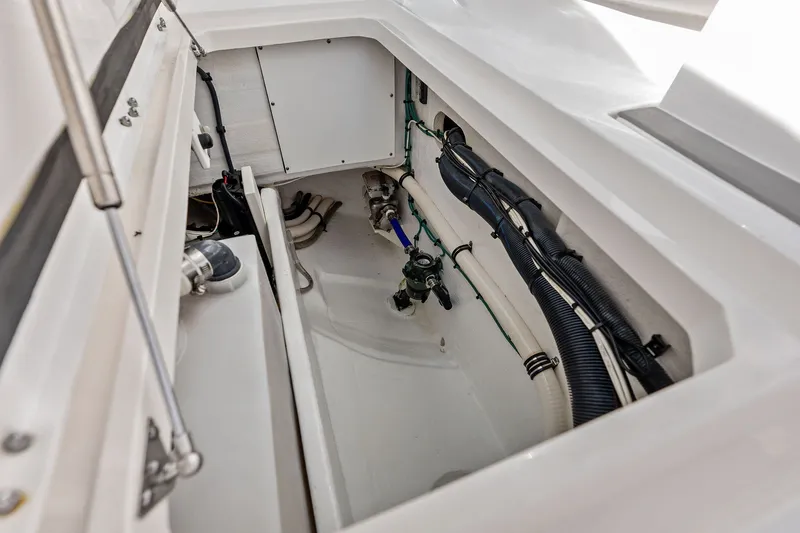Slide: The Image of Interior view of 2019 Intrepid 400 Cuddy boat's storage compartment with visible wiring and pipes. - 39