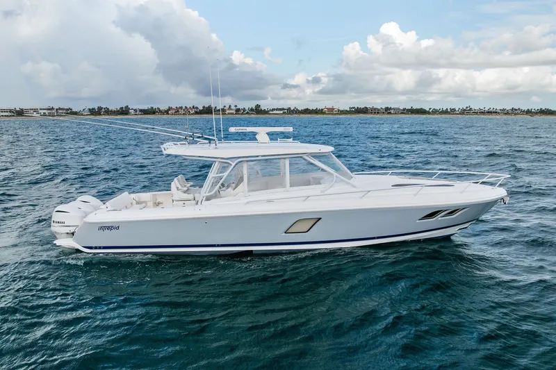 Slide: The Image of 2019 Intrepid 400 Cuddy boat cruising on open water under a cloudy sky. - 5