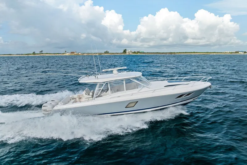The Image of 2019 Intrepid 400 Cuddy cruising on open water under a cloudy sky. - 0