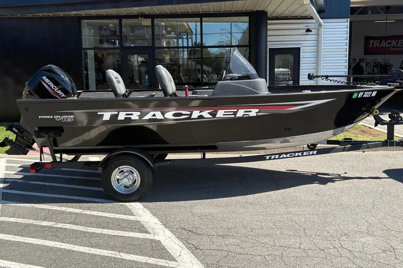 The Image of 2025 Tracker Pro Guide V-16 SC boat on trailer outside dealership. - 0