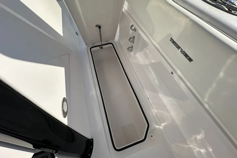 Slide: The Image of 2026 Twin Vee 280 GFX2 CC boat interior with storage compartment and sleek design. - 14