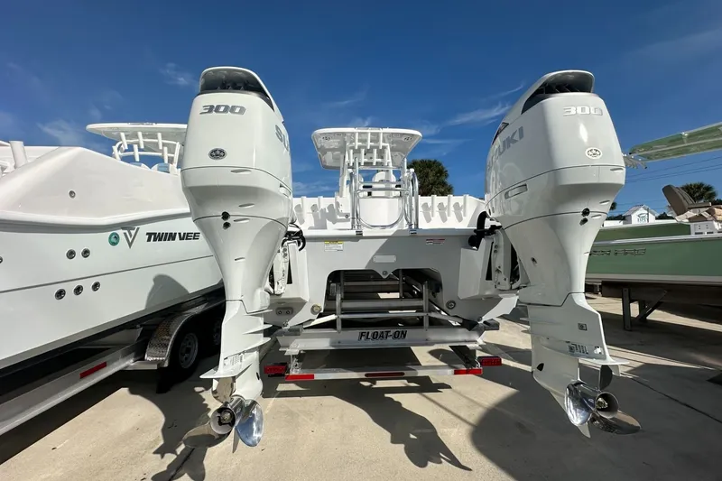 Slide: The Image of 2026 Twin Vee 280 GFX2 CC boat with dual Suzuki 300 engines on trailer. - 2