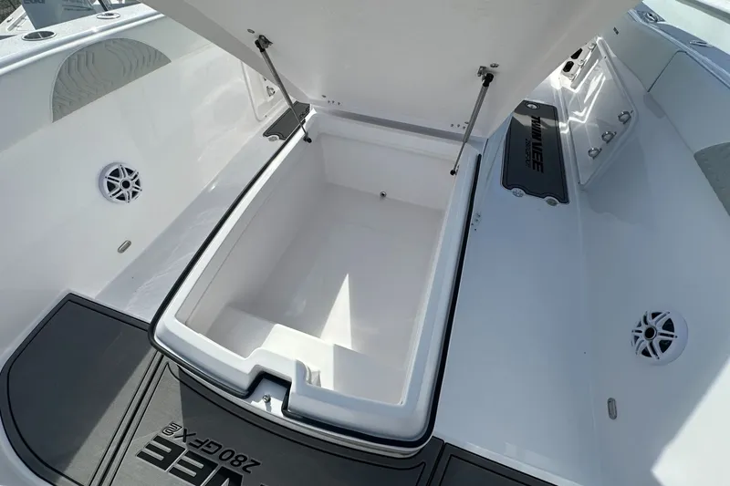 Slide: The Image of 2026 Twin Vee 280 GFX2 CC boat interior with open storage compartment and speakers. - 7