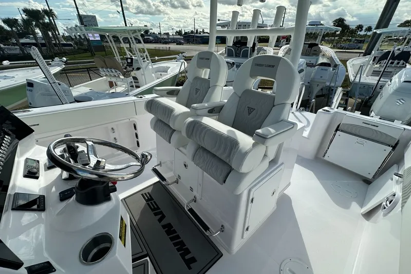 Slide: The Image of 2026 Twin Vee 280 GFX2 CC boat interior with dual captain's chairs and steering console. - 10