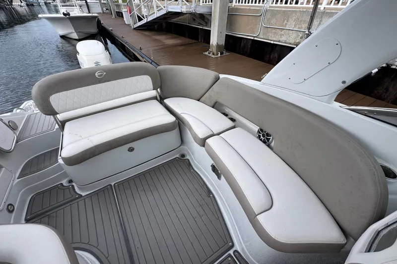 Slide: The Image of 2019 Crownline Eclipse E275 XS boat interior with cushioned seating and dockside view. - 4