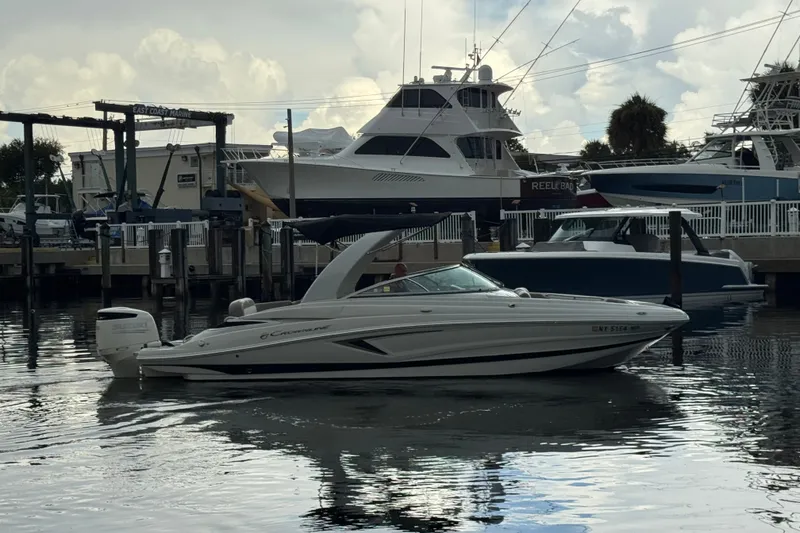 Slide: The Image of 2019 Crownline Eclipse E275 XS boat docked at a marina with other vessels. - 1