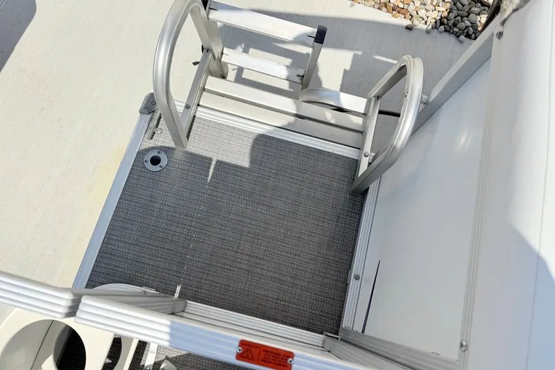 Slide: The Image of 2009 Crest 20 Caribbean boat ladder and deck, featuring metal railings and textured flooring. - 10