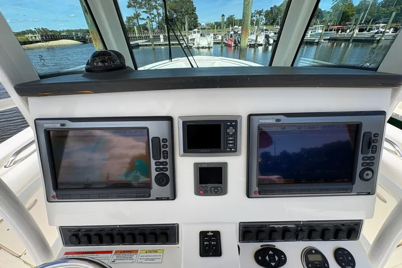 Slide: The Image of Control panel of a 2011 Boston Whaler 320 Outrage with navigation screens and controls. - 19