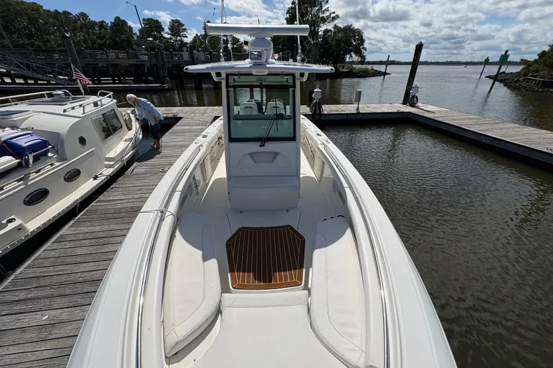 Slide: The Image of 2011 Boston Whaler 320 Outrage docked, showcasing sleek design and spacious deck. - 24