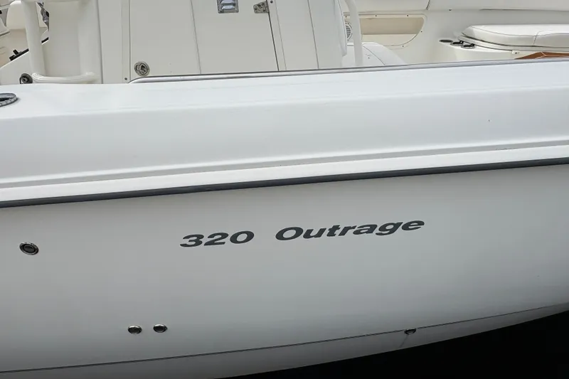 Slide: The Image of 2011 Boston Whaler 320 Outrage boat side view with model name visible. - 54