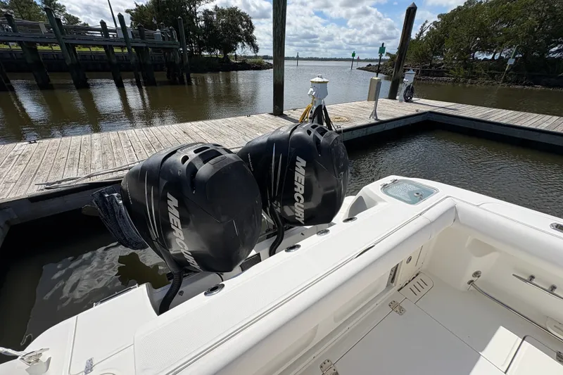 Slide: The Image of 2011 Boston Whaler 320 Outrage with twin Mercury engines docked by a wooden pier. - 28