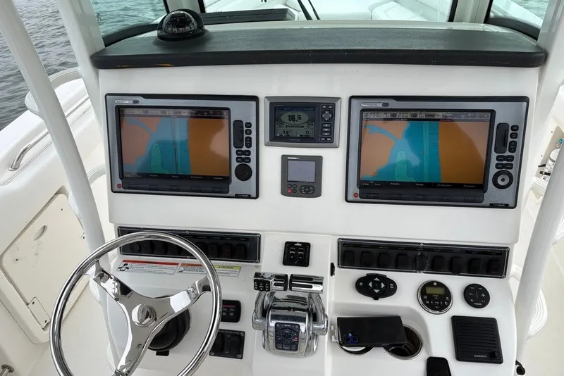 Slide: The Image of Control panel of a 2011 Boston Whaler 320 Outrage with navigation screens and steering wheel. - 22