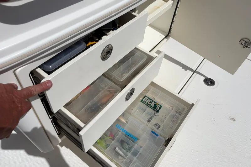 Slide: The Image of Storage drawers on a 2011 Boston Whaler 320 Outrage, containing fishing tackle boxes. - 50