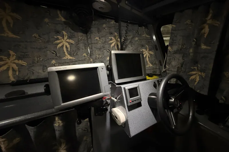 Slide: The Image of Pilothouse interior of 2012 Wooldridge 29 Super Sport with navigation equipment and tropical curtains. - 15
