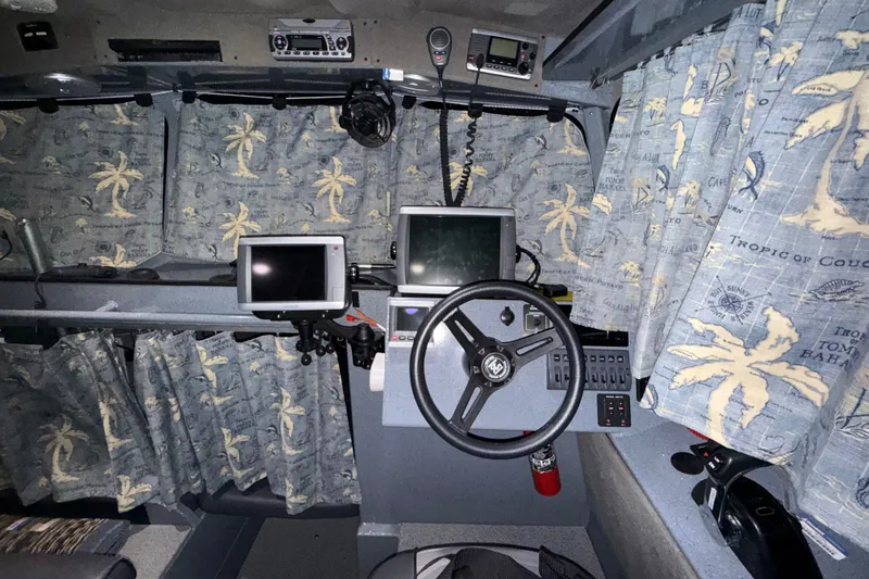 Slide: The Image of Pilothouse interior of 2012 Wooldridge 29 Super Sport with nautical-themed curtains and navigation equipment. - 14