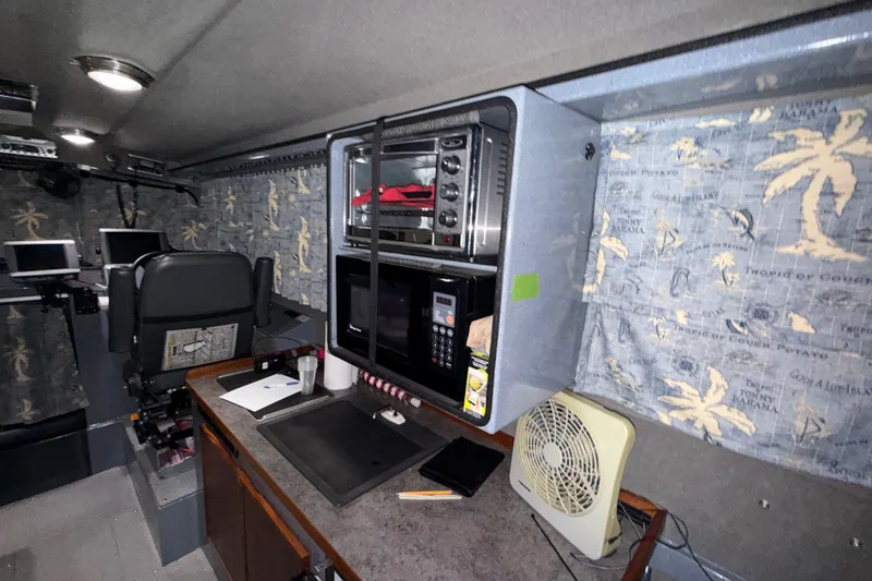 Slide: The Image of Interior of 2012 Wooldridge 29 Super Sport Pilothouse with kitchenette and nautical-themed curtains. - 9