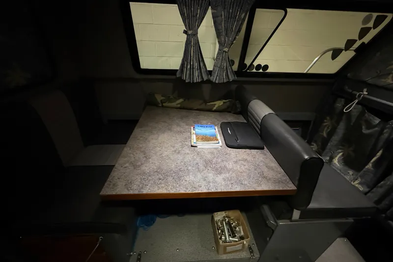 Slide: The Image of Interior of 2012 Wooldridge 29 Super Sport Pilothouse with table, book, and laptop. - 18