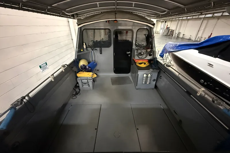 Slide: The Image of Interior of a 2012 Wooldridge 29 Super Sport Pilothouse boat in a garage setting. - 5