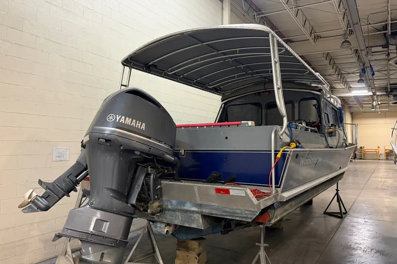 Slide: The Image of 2012 Wooldridge 29 Super Sport Pilothouse boat with Yamaha outboard motor in a warehouse. - 2