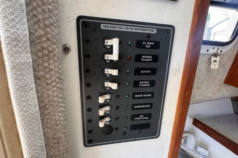 Slide: The Image of Electrical panel on 2005 Atlas Boat Works Acadia 25, showing circuit breakers and switches. - 28