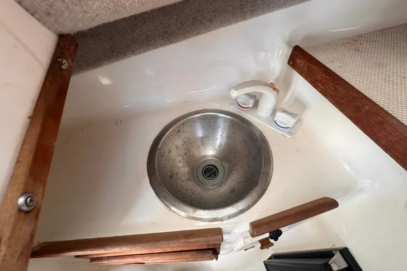 Slide: The Image of 2005 Atlas Boat Works Acadia 25 sink with faucet, wooden accents, and compact design. - 31
