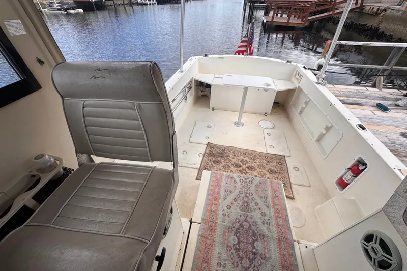 Slide: The Image of 2005 Atlas Boat Works Acadia 25 interior with seating, table, and dockside view. - 43