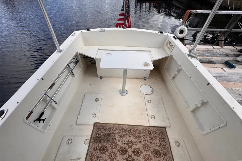 Slide: The Image of 2005 Atlas Boat Works Acadia 25 cockpit with table, American flag, and dockside view. - 46