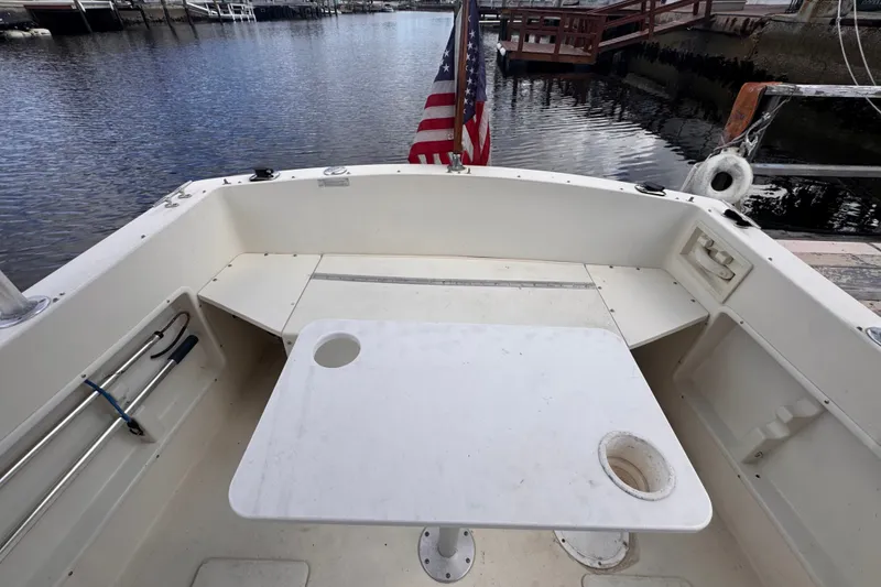 Slide: The Image of Cockpit of 2005 Atlas Boat Works Acadia 25 with table and American flag. - 45