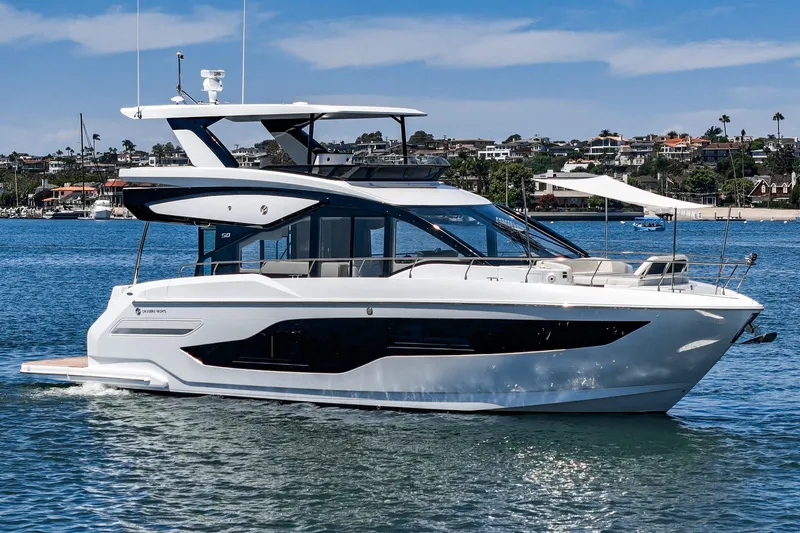 Slide: The Image of 2027 Cruisers Yachts 50 Fly luxury yacht on calm water, showcasing sleek design. - 19