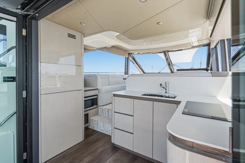 Slide: The Image of Luxurious interior of 2027 Cruisers Yachts 50 Fly, featuring modern kitchen and seating area. - 53