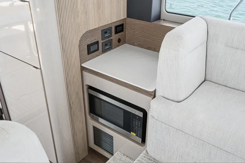 Slide: The Image of Modern interior of 2027 Cruisers Yachts 50 Fly with microwave and seating area. - 54