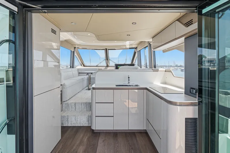 Slide: The Image of Luxurious interior of 2027 Cruisers Yachts 50 Fly, featuring modern kitchen and spacious seating. - 52