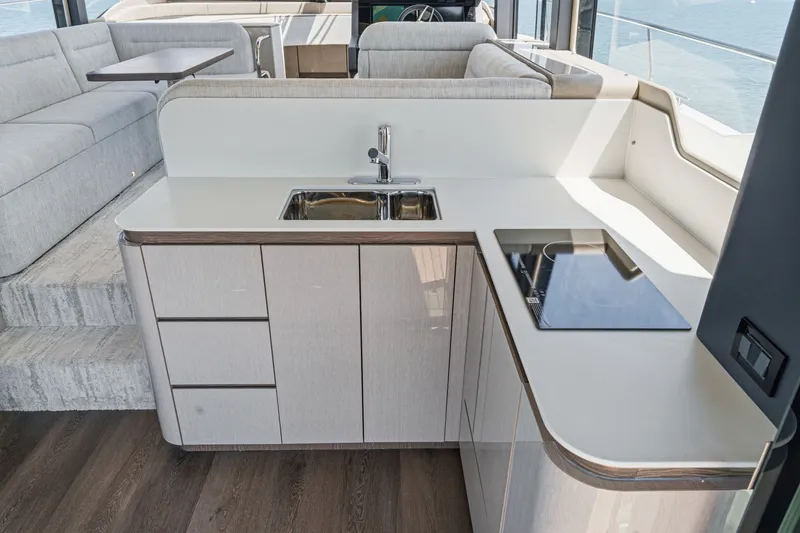 Slide: The Image of Modern kitchen area on 2027 Cruisers Yachts 50 Fly, featuring sleek cabinetry and appliances. - 58