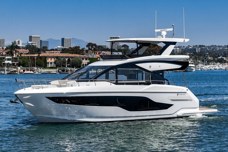 Slide: The Image of 2027 Cruisers Yachts 50 Fly luxury yacht cruising near urban skyline. - 3