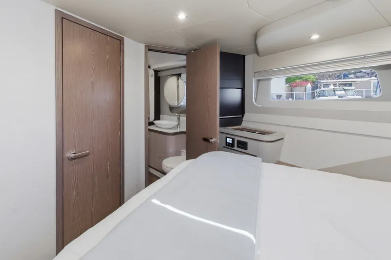 Slide: The Image of Luxurious interior of 2027 Cruisers Yachts 50 Fly, featuring modern bedroom and ensuite bathroom. - 84
