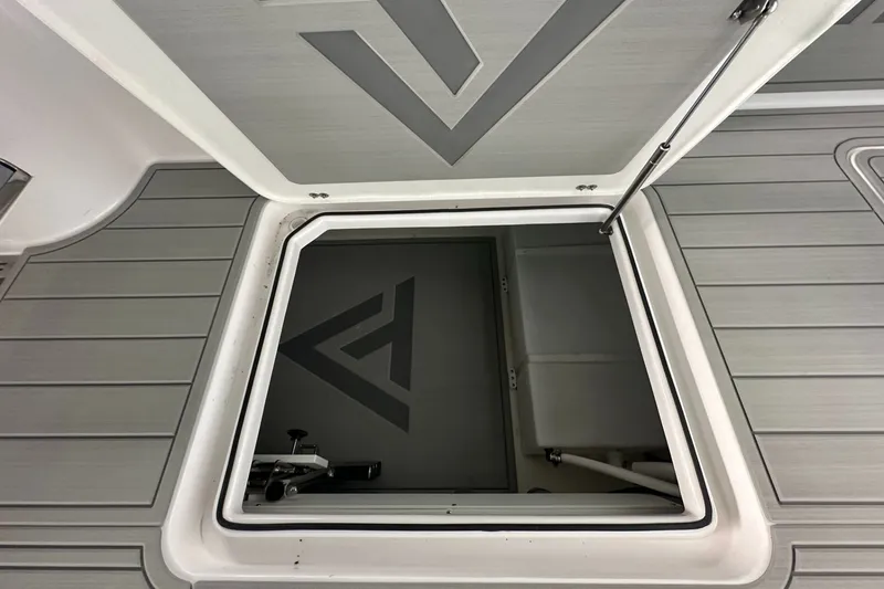 Slide: The Image of Open hatch on 2025 Twin Vee 400 GFX2 CC boat deck, revealing storage compartment. - 15