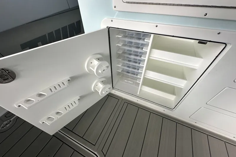 Slide: The Image of Open storage compartment on 2025 Twin Vee 400 GFX2 CC boat, featuring organized shelves and holders. - 21