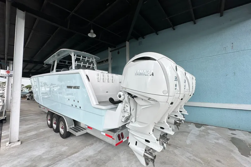 Slide: The Image of 2025 Twin Vee 400 GFX2 CC boat with Yamaha outboard engines, parked under a shelter. - 5