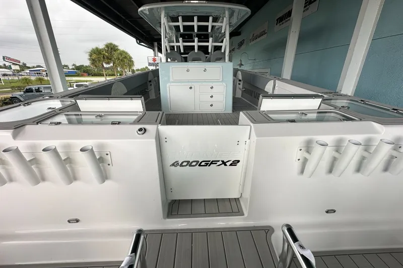 Slide: The Image of 2025 Twin Vee 400 GFX2 CC boat interior with rod holders and storage compartments. - 10