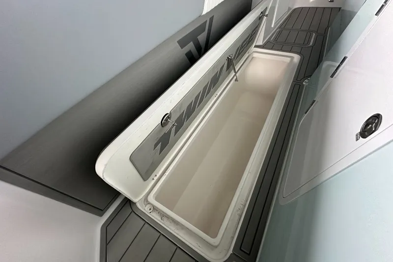 Slide: The Image of 2025 Twin Vee 400 GFX2 CC boat storage compartment with open lid, showcasing interior space. - 30