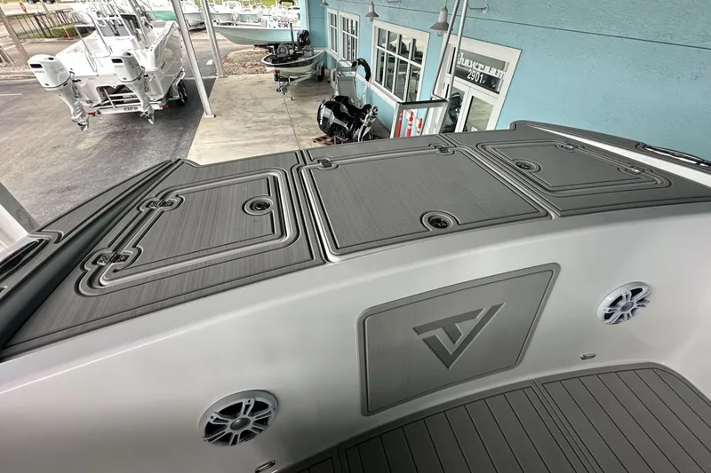 Slide: The Image of 2025 Twin Vee 400 GFX2 CC boat deck with storage compartments and logo. - 36