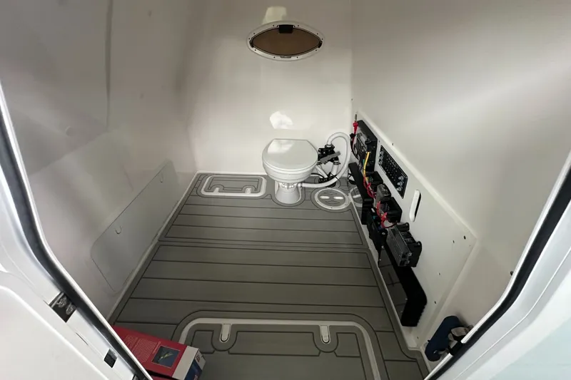Slide: The Image of Interior of 2025 Twin Vee 400 GFX2 CC boat, featuring a compact marine toilet. - 43