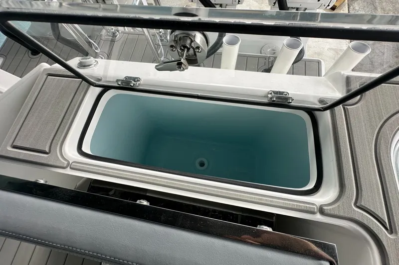 Slide: The Image of 2025 Twin Vee 400 GFX2 CC boat storage compartment with open lid and rod holders. - 13