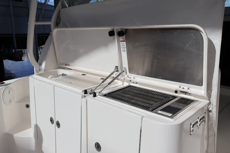 Slide: The Image of 2023 Pursuit OS 385 Offshore boat with onboard grill and sink setup. - 23