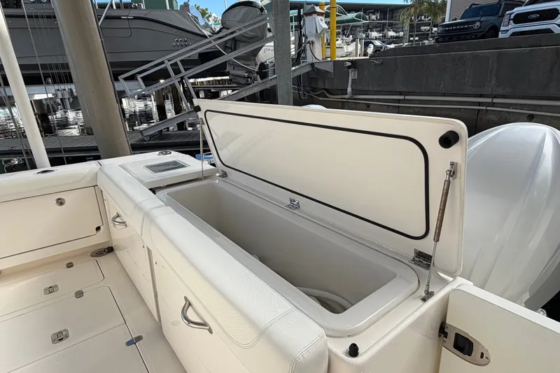 Slide: The Image of 2023 Pursuit OS 385 Offshore boat with open storage compartment at marina. - 19