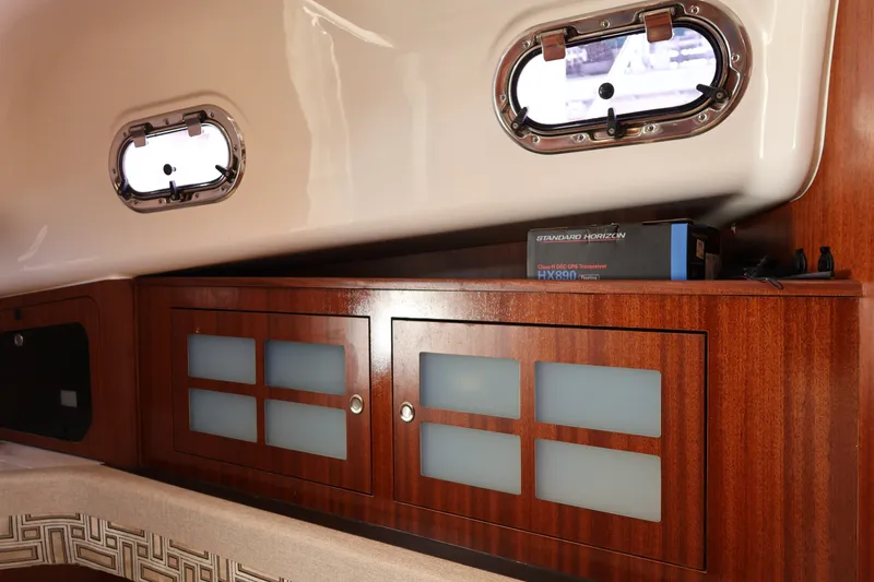 Slide: The Image of 2023 Pursuit OS 385 Offshore interior with wooden cabinets and portholes. - 47